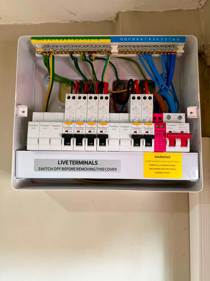 Newly installed consumer unit with the cover off, showing RCBOs and a surge protection device